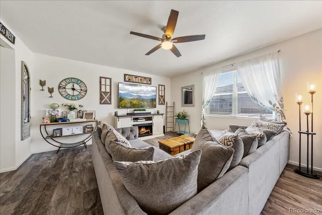 a living room with furniture and a ceiling fan