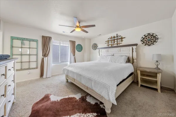 a bedroom with a bed and a ceiling fan
