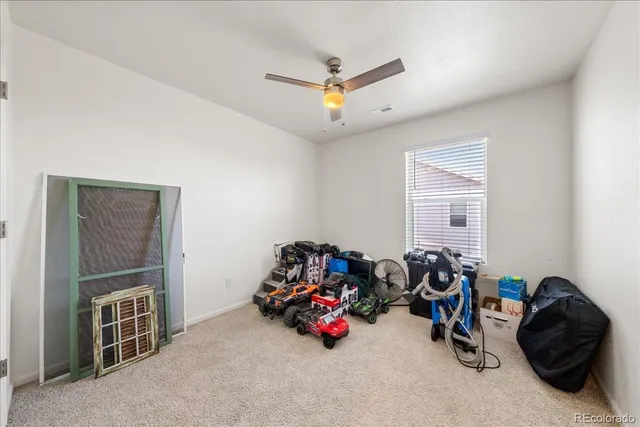 an empty room with a ceiling fan and window