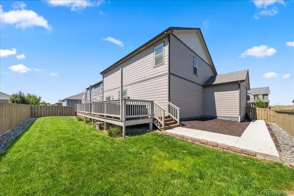 a view of a house with a wooden deck and furniture