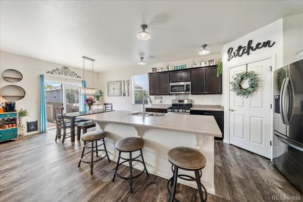a view of a dining room with furniture a chandelier and wooden floor