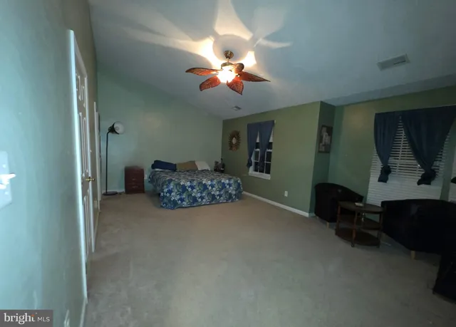 a living room with furniture a ceiling fan and a window