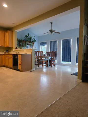 a living room with furniture a fireplace and kitchen view