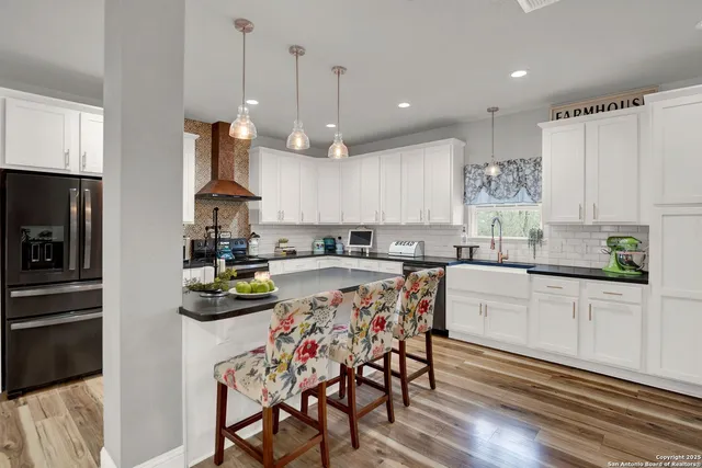 a kitchen with white cabinets and sink
