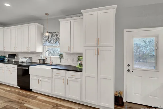 a kitchen with stainless steel appliances granite countertop a sink a stove and a wooden floors