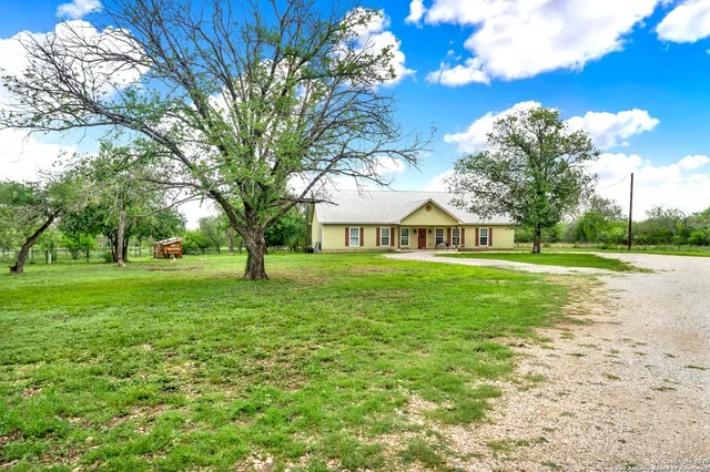 a view of an house with backyard and trees