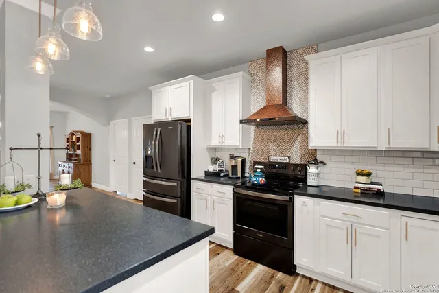 a kitchen with stainless steel appliances granite countertop a sink a stove top oven a counter space and cabinets
