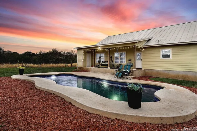 a view of a house with pool and chairs