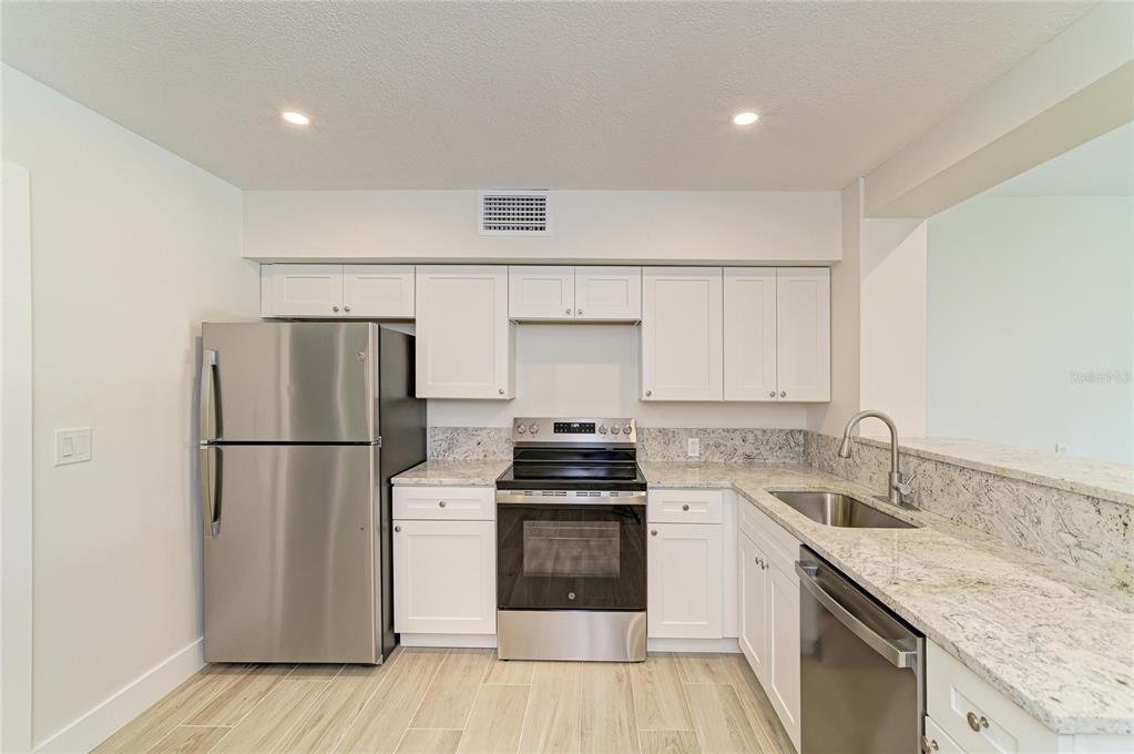 101 73rd Street, Unit 3 Holmes Beach, FL 34217 - Photo 17 of 53 a kitchen with a sink stove and refrigerator