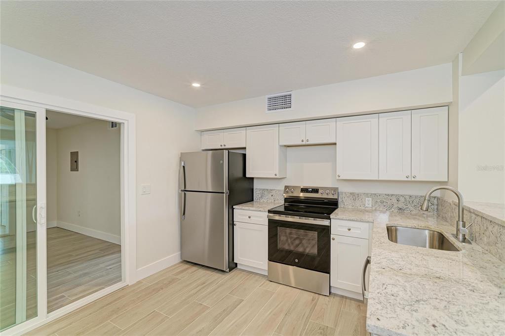 101 73rd Street, Unit 3 Holmes Beach, FL 34217 - Photo 18 of 53 a kitchen with a refrigerator a stove top oven and sink