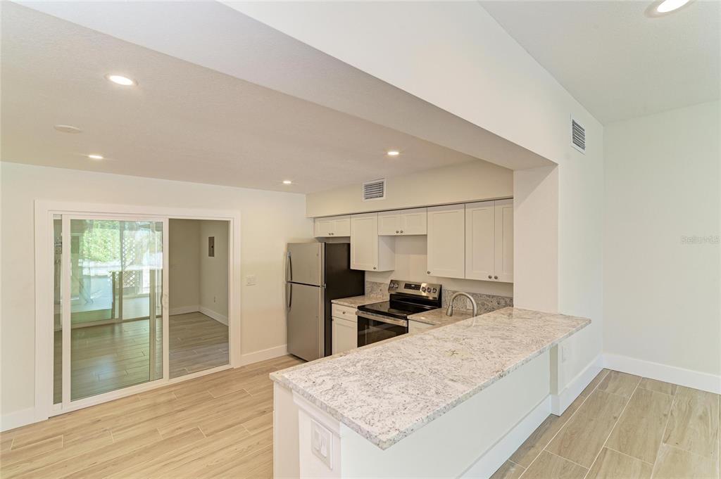 101 73rd Street, Unit 3 Holmes Beach, FL 34217 - Photo 21 of 53 a large kitchen with kitchen island a sink stainless steel appliances and cabinets