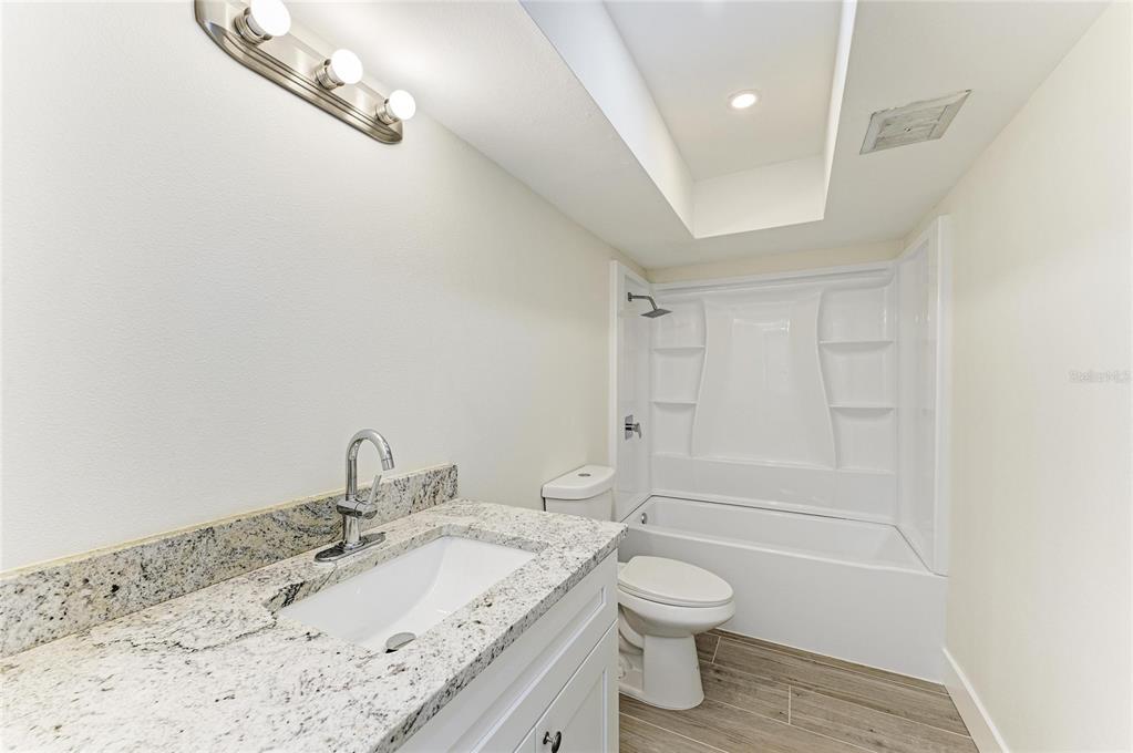 101 73rd Street, Unit 3 Holmes Beach, FL 34217 - Photo 28 of 53 a bathroom with a granite countertop sink a toilet and shower