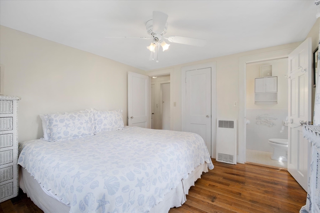 69 Jericho Path Falmouth, MA 02540 - Photo 18 of 42 a bedroom with a bed and a chandelier