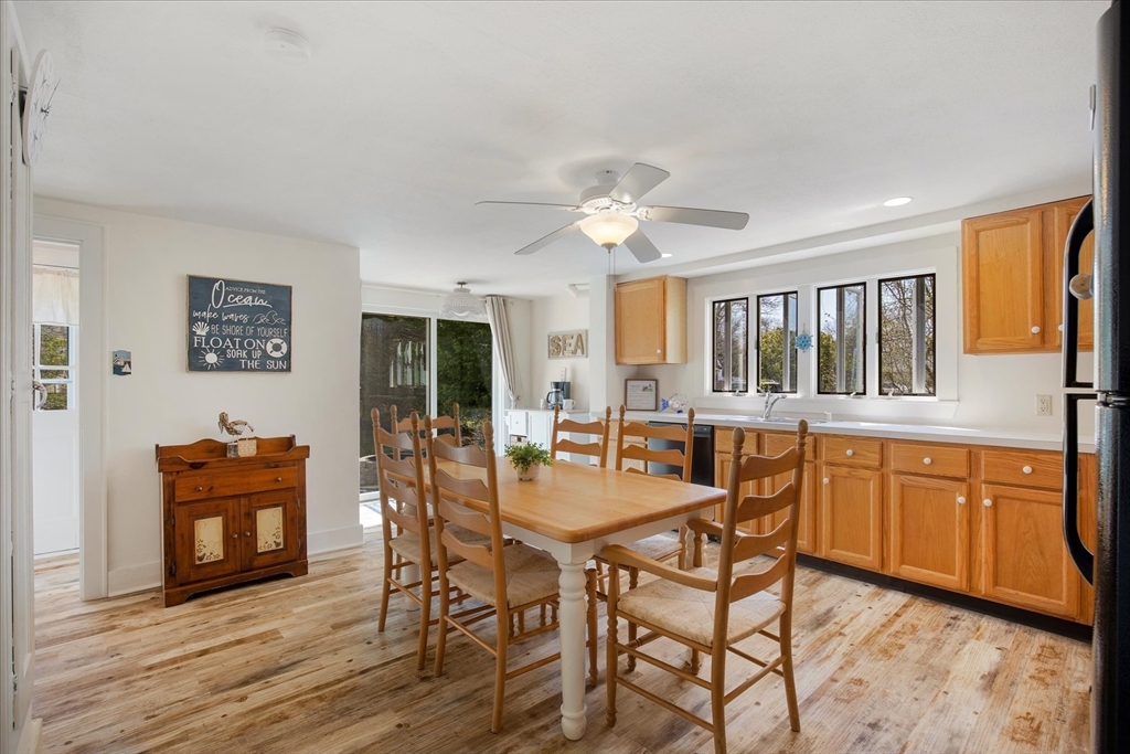 69 Jericho Path Falmouth, MA 02540 - Photo 20 of 42 a dining hall with stainless steel appliances granite countertop a stove a sink a dining table and chairs with wooden floor