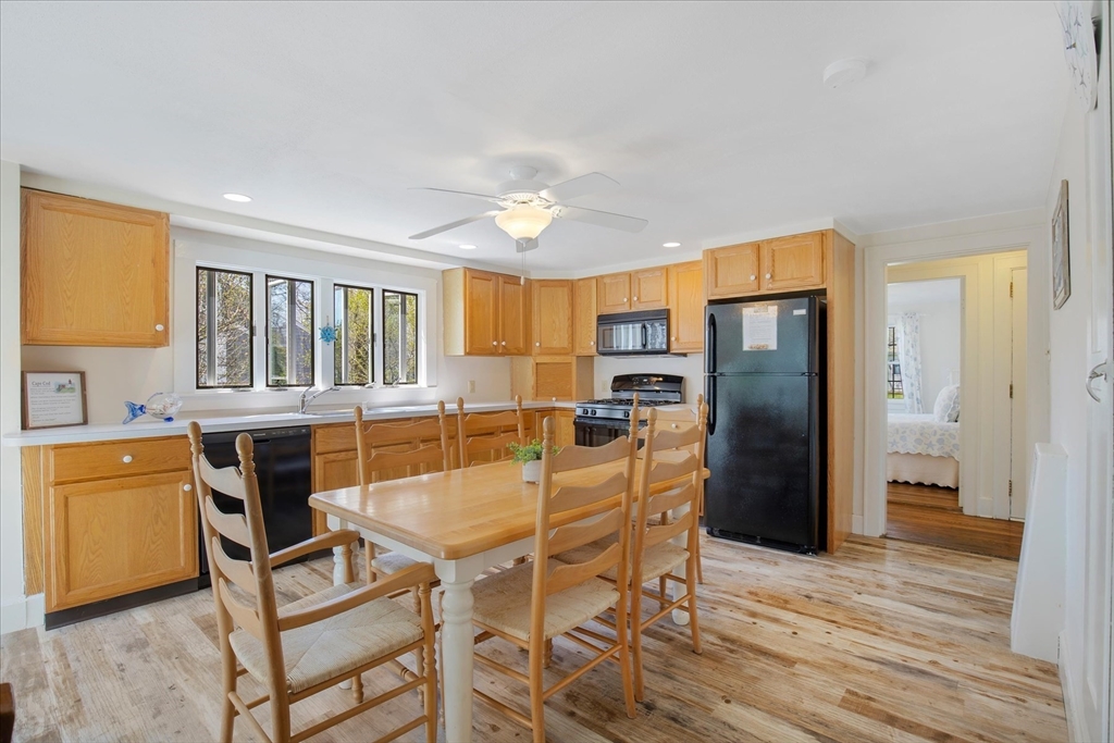 69 Jericho Path Falmouth, MA 02540 - Photo 21 of 42 a kitchen with stainless steel appliances kitchen island granite countertop a refrigerator stove microwave and cabinets