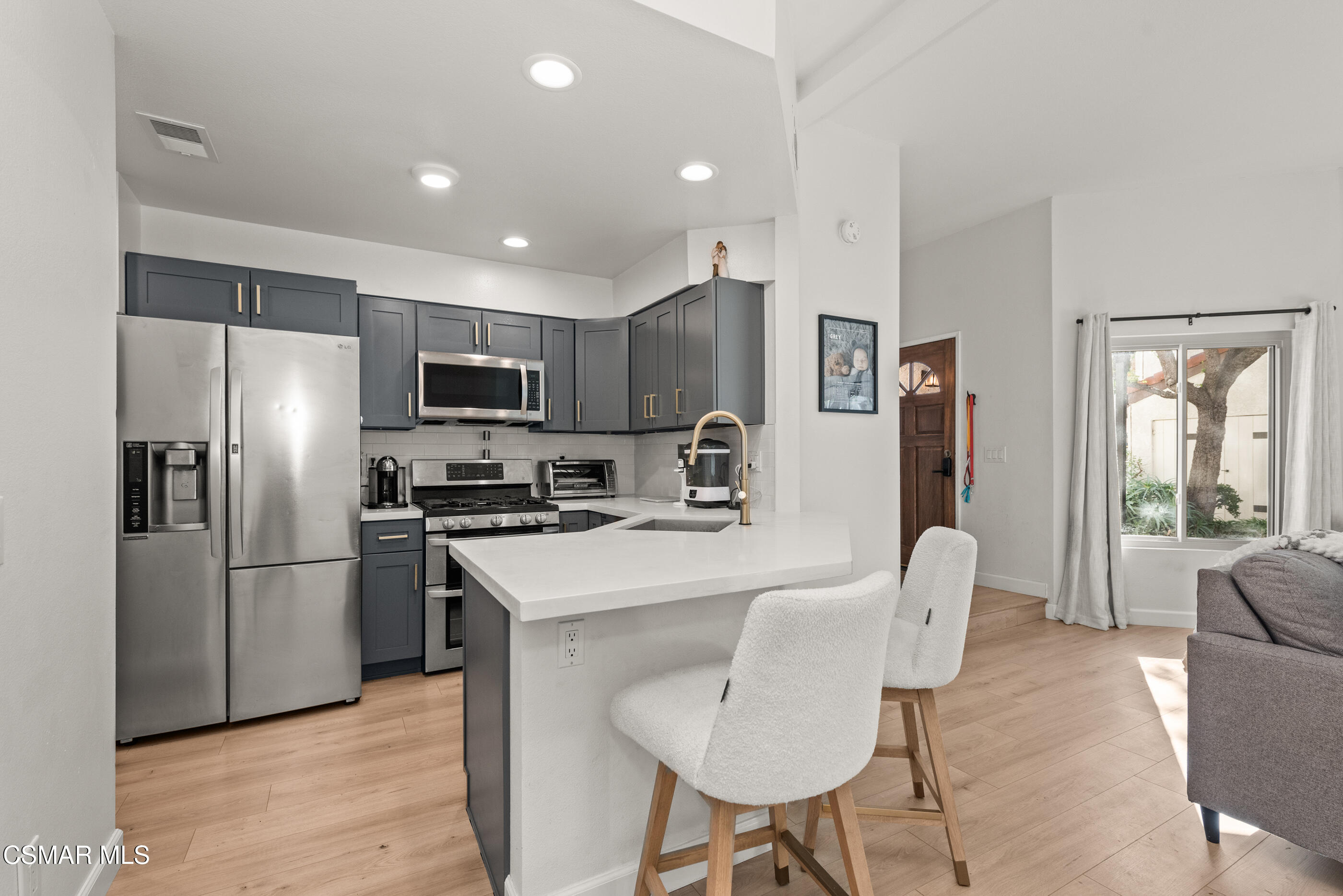 1730 Sinaloa Road, Unit 310 Simi Valley, CA 93065 - Photo 6 of 36 a kitchen with stainless steel appliances a refrigerator a stove a dining table and chairs