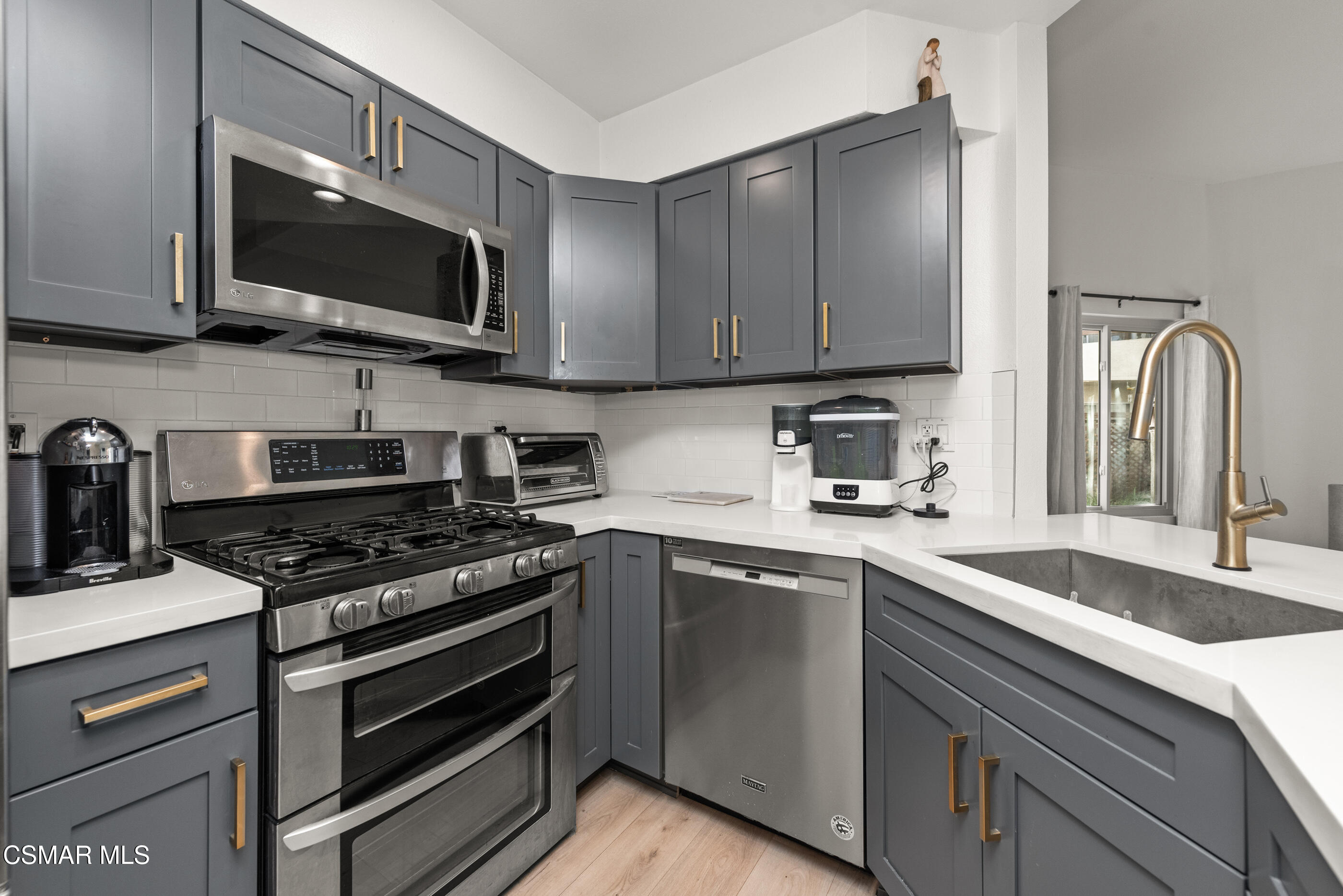 1730 Sinaloa Road, Unit 310 Simi Valley, CA 93065 - Photo 7 of 36 a kitchen with stainless steel appliances granite countertop a sink a stove and microwave