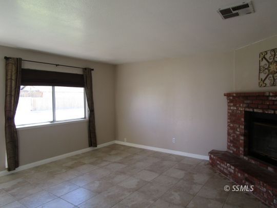 910 East Church Avenue Ridgecrest, CA 93555 - Photo 13 of 20 a living room with a fireplace and a window