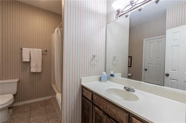 a bathroom with a sink and mirror with toilet