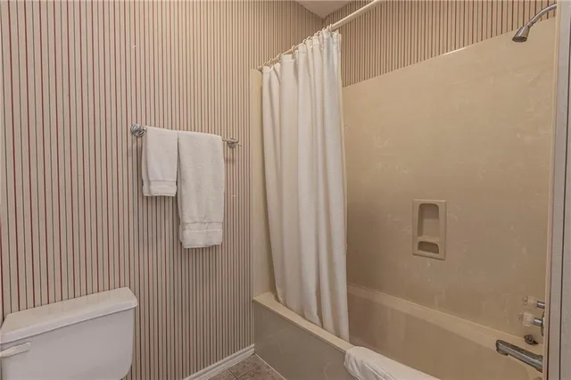 a bathroom with a shower curtain and toilet