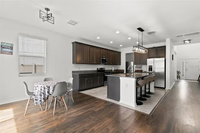 a kitchen with a table chairs microwave and cabinets