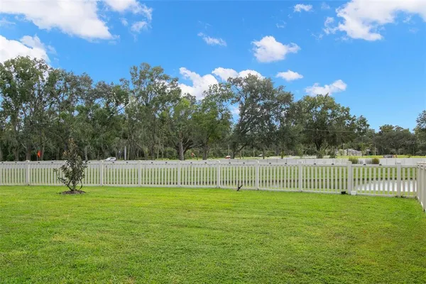 a view of a house with a yard and table chairs