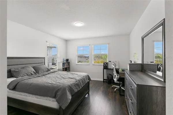 a view of a bedroom with wooden floor and a window