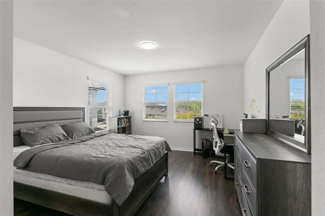 a view of a bedroom with wooden floor and a window