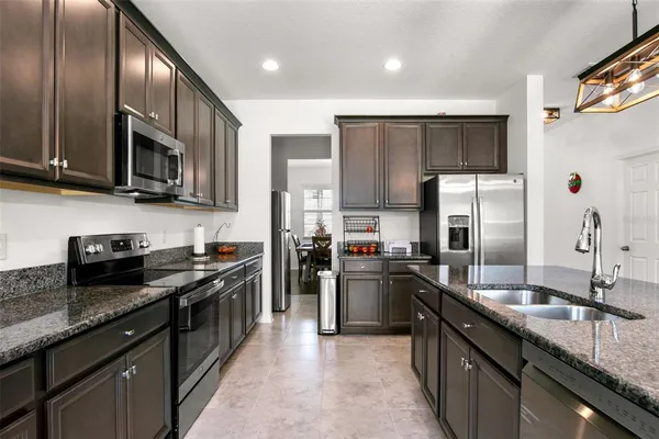 a kitchen with stainless steel appliances granite countertop a sink stove and refrigerator