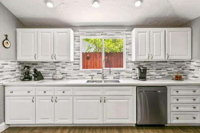 a kitchen with granite countertop a sink and cabinets