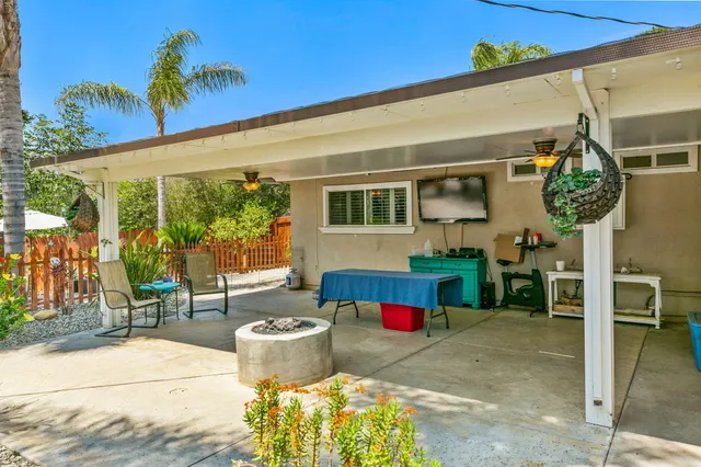 a view of a chairs and table in backyard of a house