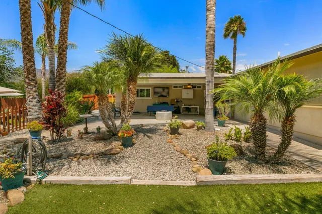 a view of a house with backyard water fountain and sitting area