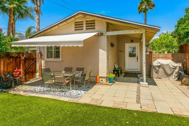 a view of a patio with table and chairs under an umbrella