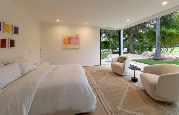 a bedroom with furniture and a large window
