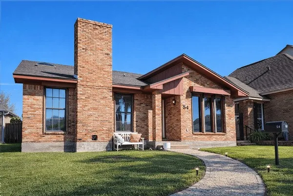 a front view of a house with a garden
