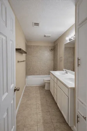 a bathroom with a granite countertop sink a toilet and shower