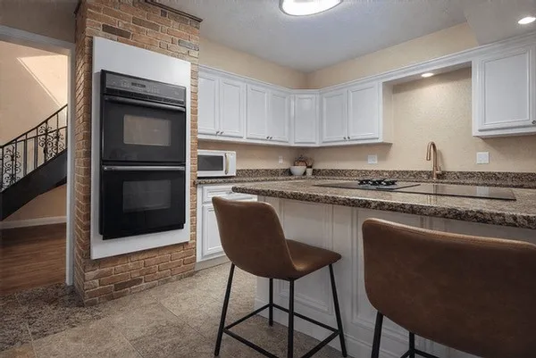 a kitchen with stainless steel appliances granite countertop a stove a sink and a microwave
