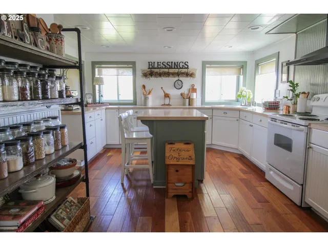 a kitchen with stainless steel appliances granite countertop a stove a sink dishwasher and a dining table with wooden cabinet