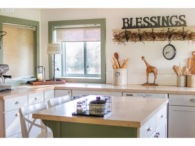 a kitchen with kitchen island granite countertop a sink and a stove with wooden floor
