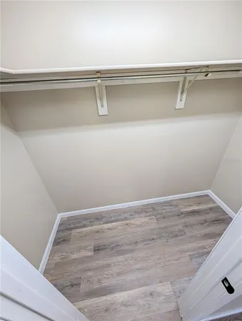 an empty room with wooden floor ceiling fan and windows