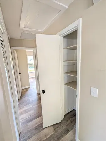 a view of a hallway with wooden floor and closet