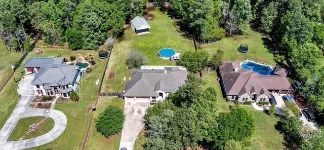 an aerial view of a house with outdoor space pool seating area and yard