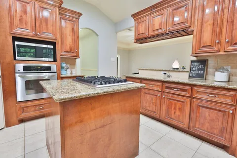 a kitchen with stainless steel appliances granite countertop a sink stove and cabinets