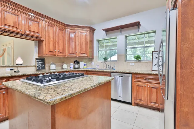 a kitchen with stainless steel appliances granite countertop a refrigerator stove and sink