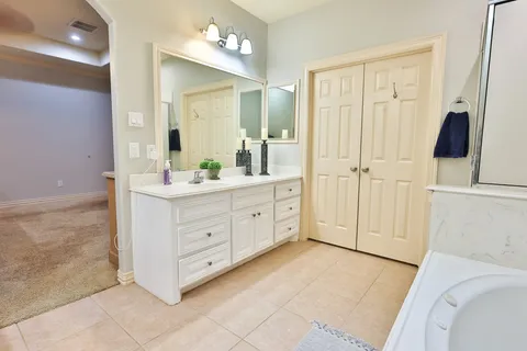 a bathroom with a tub sink and mirror