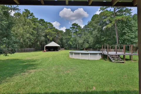 a view of a chair and table in backyard of the house