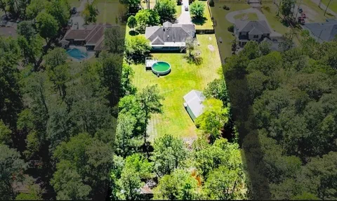 an aerial view of residential house with swimming pool and garden space