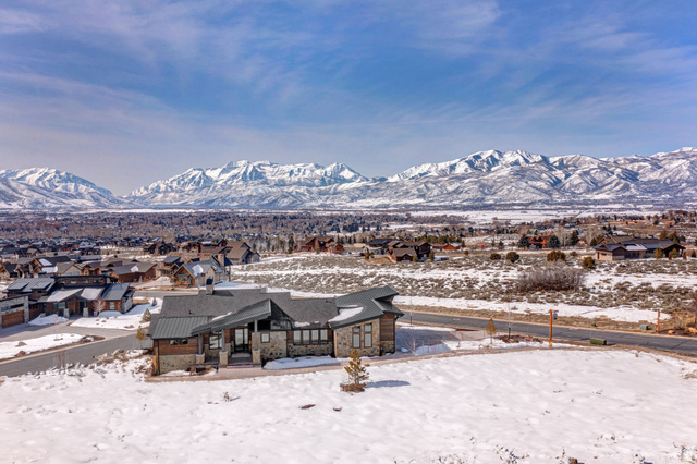 1282 Chimney Rock Road, Unit 344 Heber City, UT 84032 - Photo 54 of 55 Contemporary residence featuring mixed material exterior with stone accents and dark siding, a multi-pitched roofline, and an expansive paved driveway
