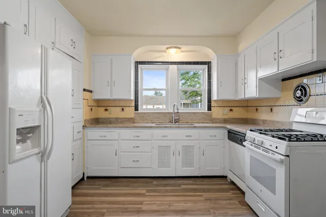 a kitchen with granite countertop a sink stainless steel appliances and cabinets