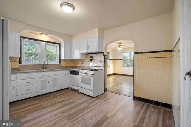 a kitchen with a refrigerator and white cabinets